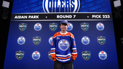 Aidan Park at NHL Draft in from of selection board
